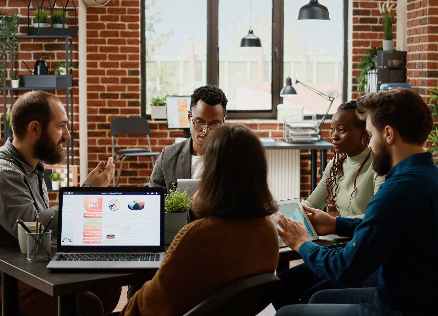 Team collaborating in brick-walled office for staff extension engagement