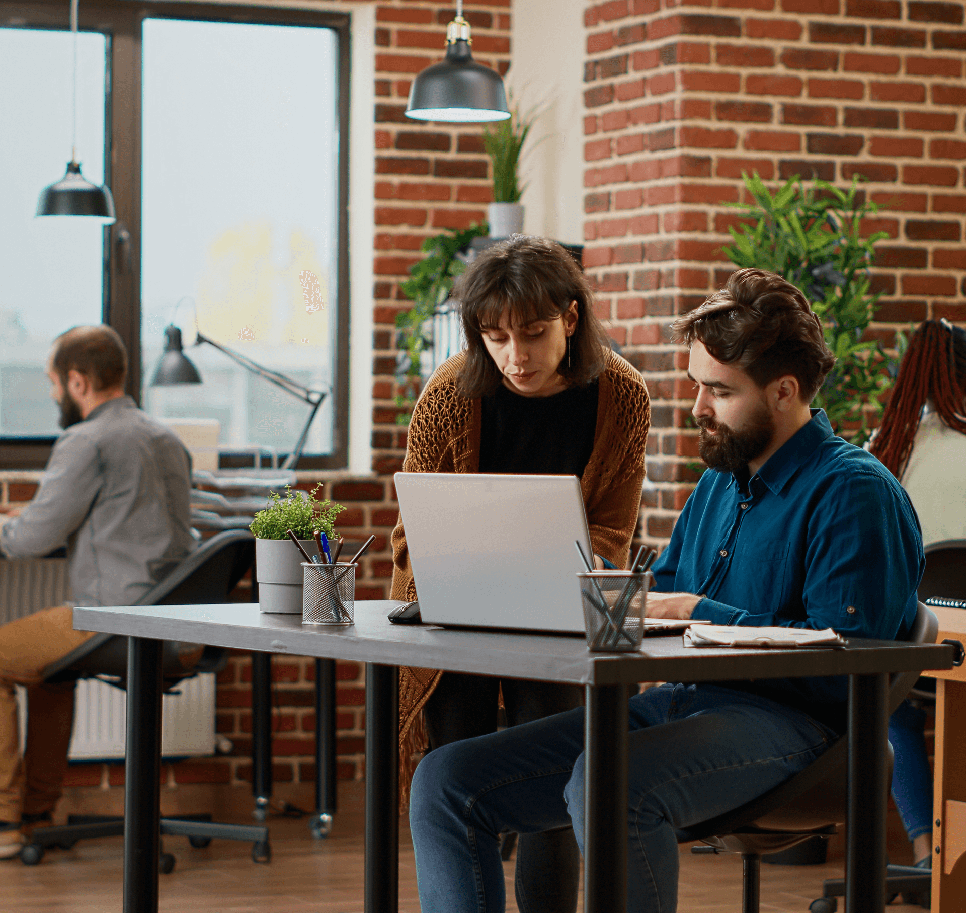 Zentexx Austin product team collaborating on laptop in brick-walled office