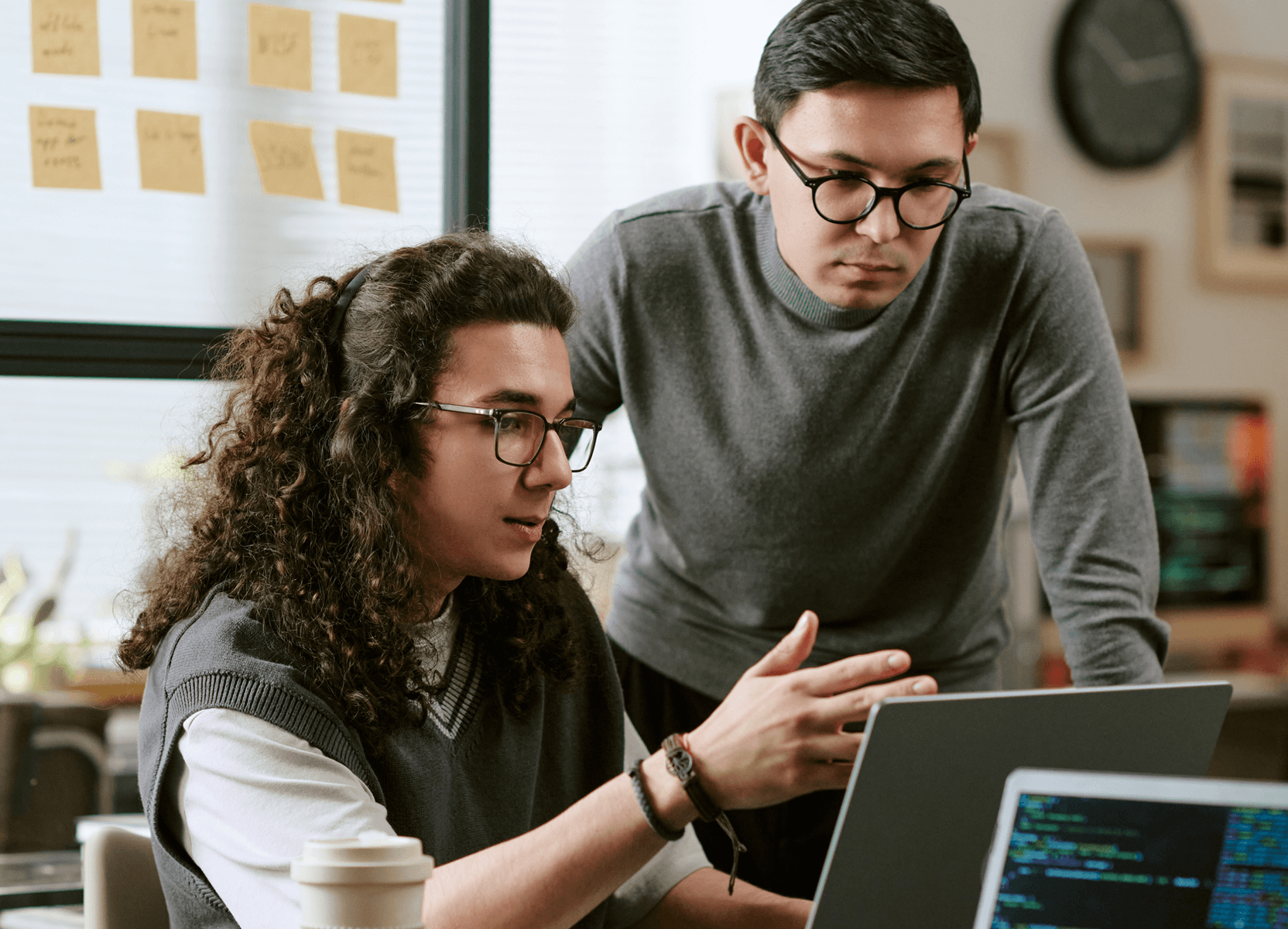Two developers reviewing code on laptop for project-based augmentation engagement